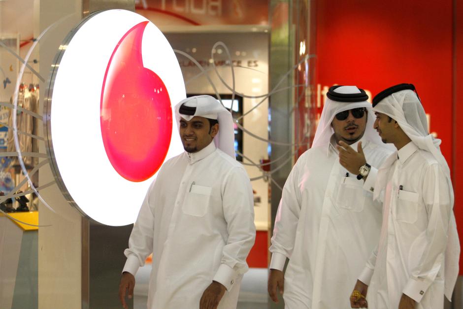 Men walk past a Vodafone-Qatar Telecommunication office in Doha October 22,2009. Reuters / Fadi Al-Assaad