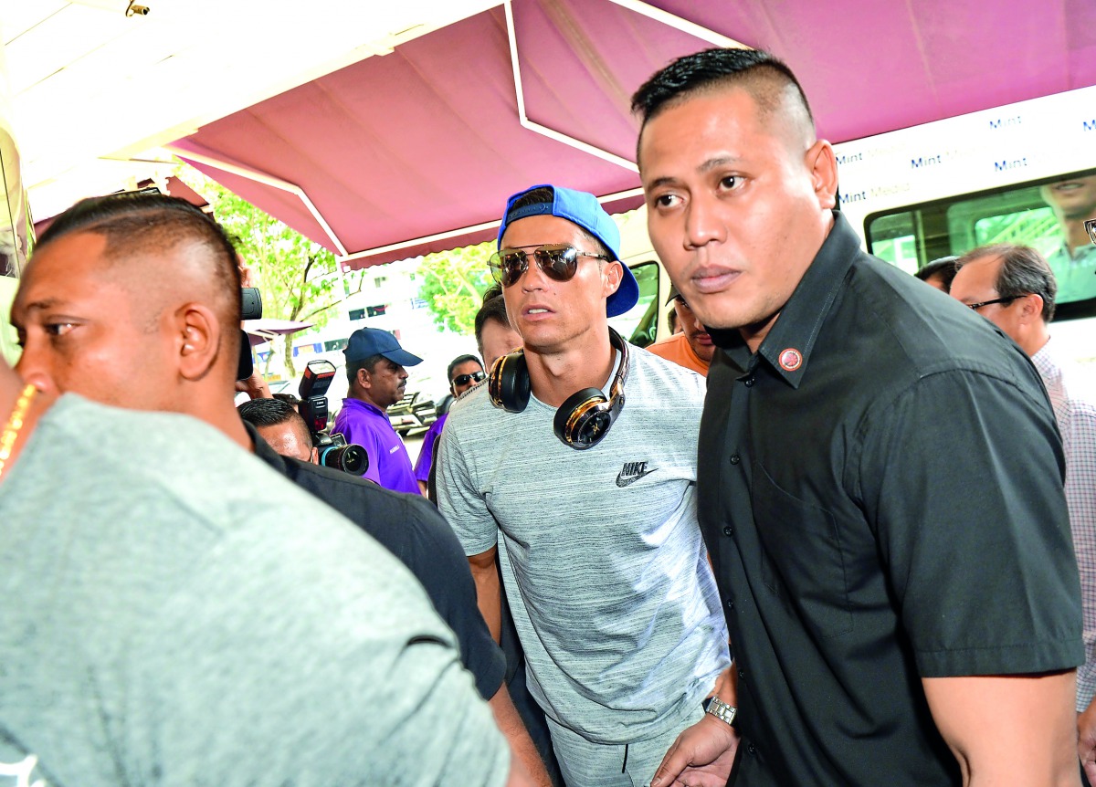 Portugal’s Cristiano Ronaldo (centre) arrives at Thomson Medical Hospital in Singapore to visit the daughter of billionaire Peter Lim yesterday.