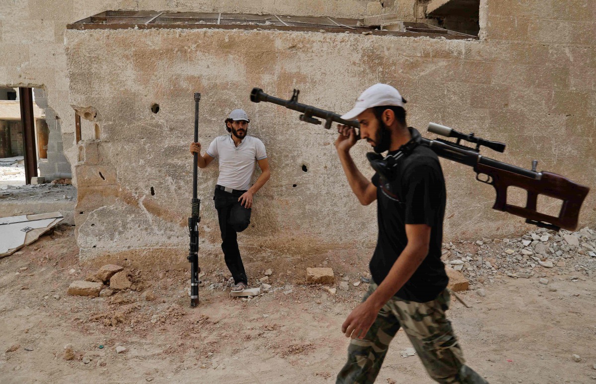 Syrian rebel fighters from the Faylaq al-Rahman brigade carry their homemade 12.7mm sniper rifle in Ain Tarma, in the eastern Ghouta area, a rebel stronghold east of the capital Damascus, on July 20, 2017. (AFP / ABDULMONAM EASSA)