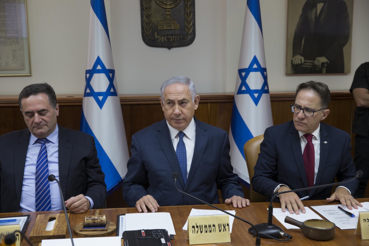 Israeli Prime Minister Benjamin Netanyahu (C), flanked by Government Secretary Tzachi Braverman (R) and Minister of Transportation Israel Katz, attends the weekly cabinet meeting at his office in Jerusalem on July 23, 2017. AFP / Abir Sultan

