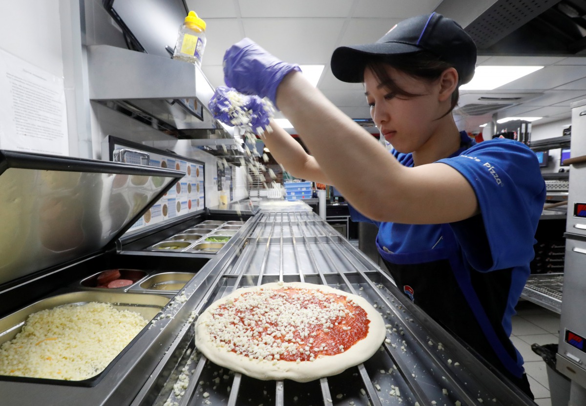 A staff member prepares a pizza at a Domino's Pizza restaurant in Moscow, Russia, July 14, 2017. Picture taken July 14, 2017. REUTERS/Sergei Karpukhin