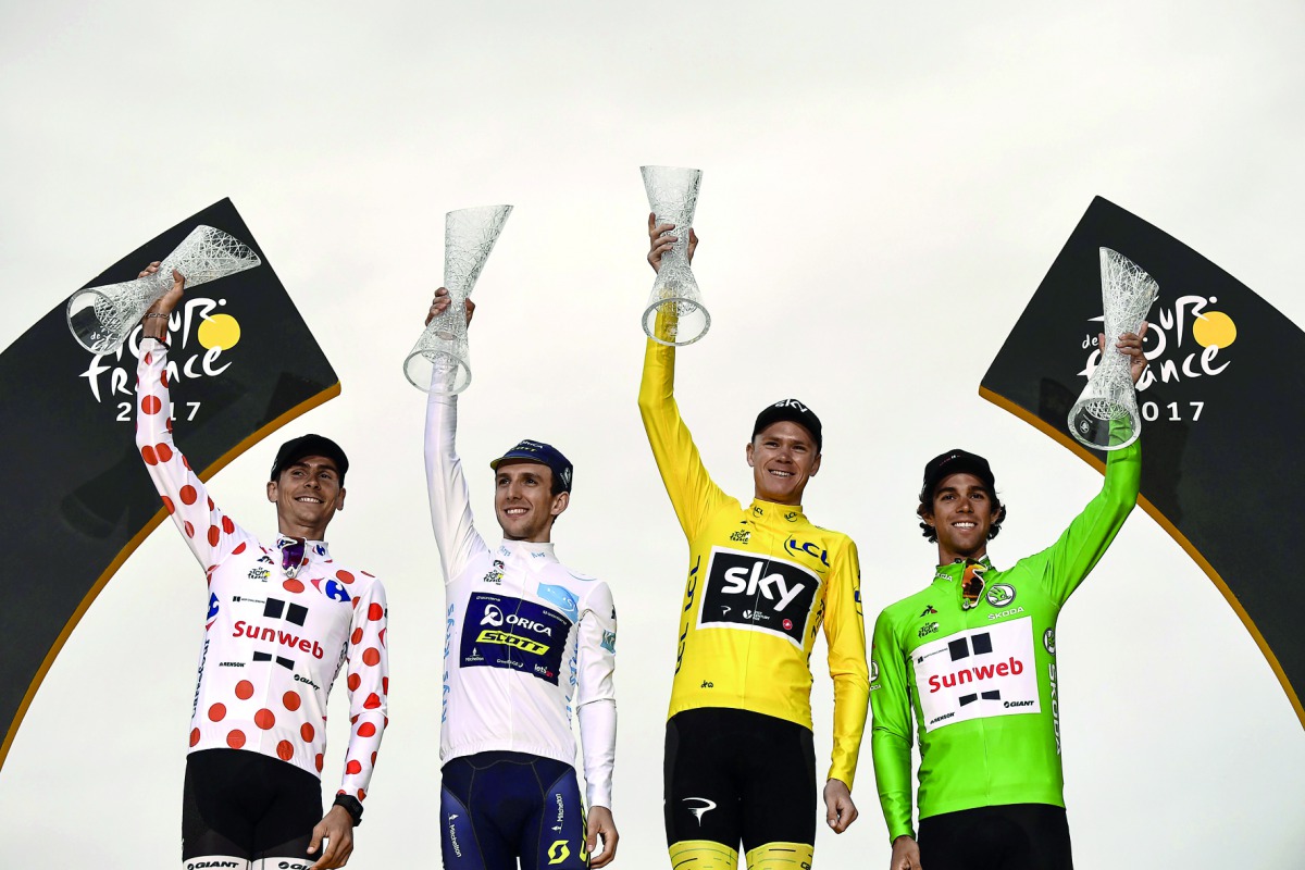 (From left) France’s Warren Barguil wearing the best climber’s polka dot jersey, Great Britain’s Simon Yates wearing the best young’s white jersey, Tour de France 2017’s winner Great Britain’s Christopher Froome, wearing the overall leader’s yellow jersey