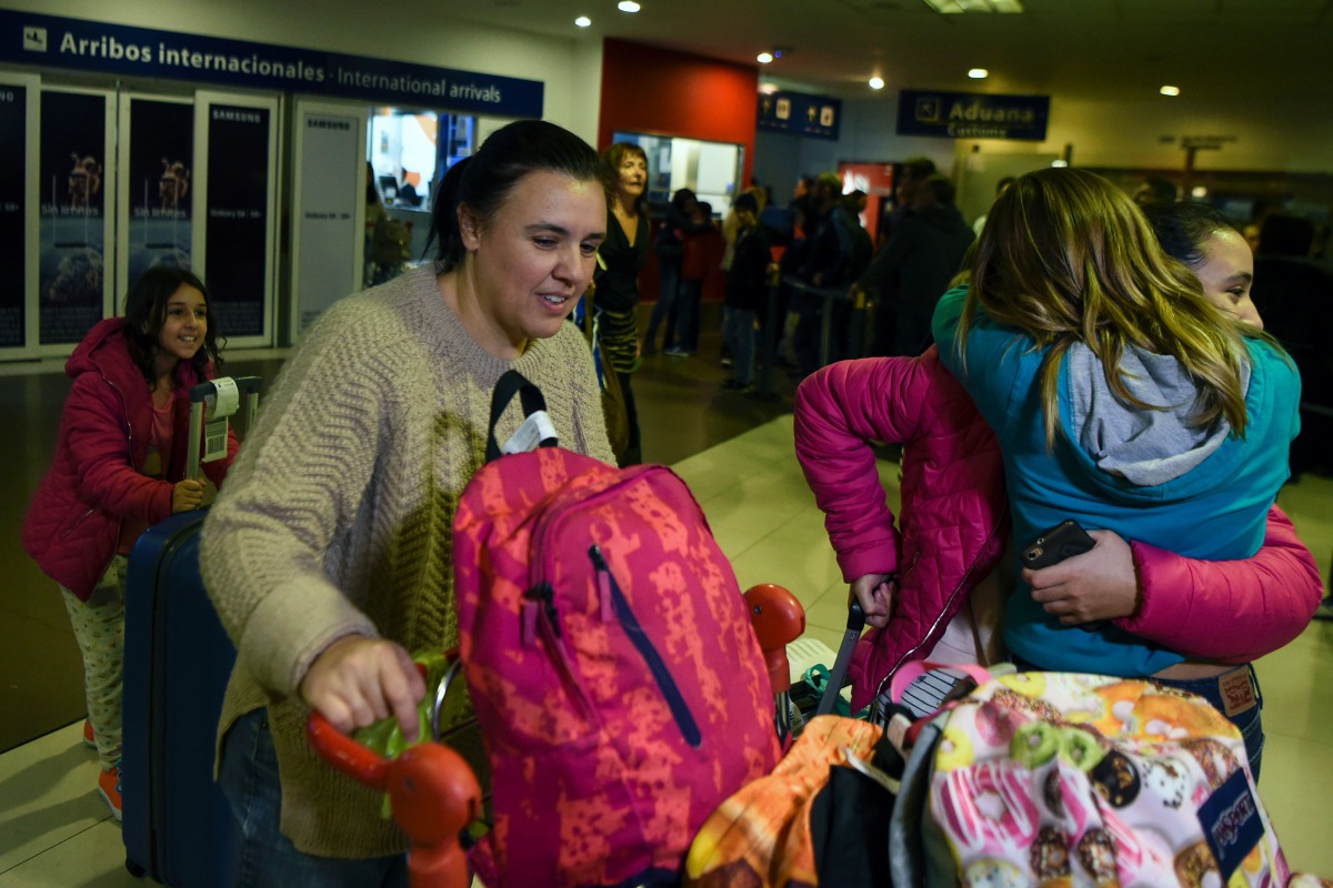 Valeria Marsili (2-L), wife of Gabriel Aguero, an Argentinean chef who works in Qatar, and their daughters are greeted by a relative upon her arrival at Ezeiza international airport in Buenos Aires on August 09, 2017. (AFP / EITAN ABRAMOVICH)