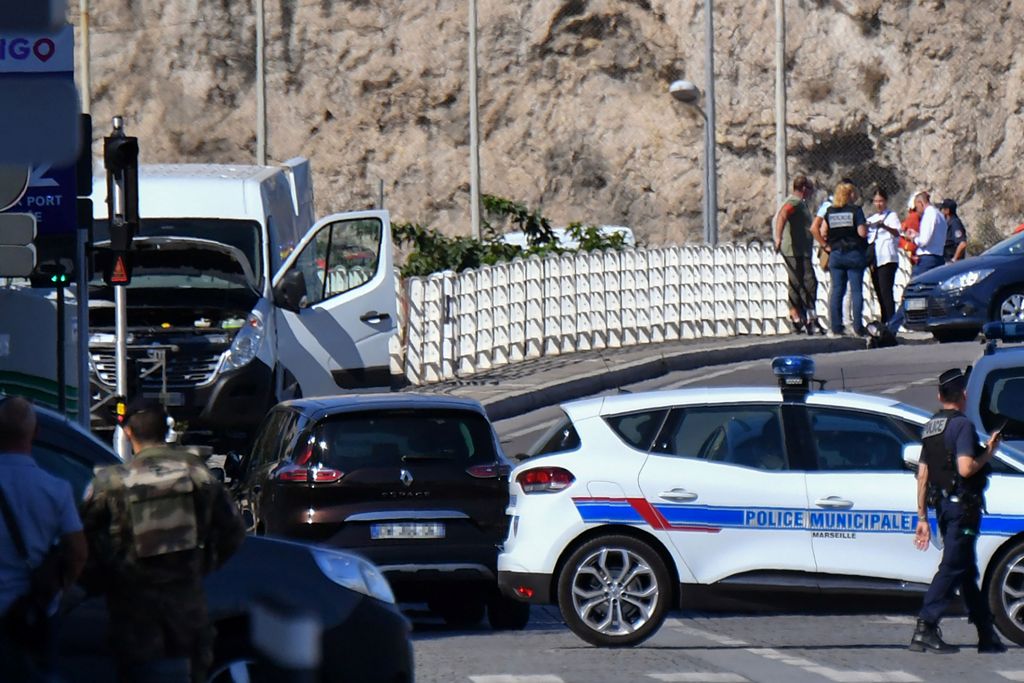 French forensic police officers and security personnel gather near a vehicle following a car crash in the southern Mediterranean city of Marseille on August 21, 2017. AFP / BERTRAND LANGLOIS
