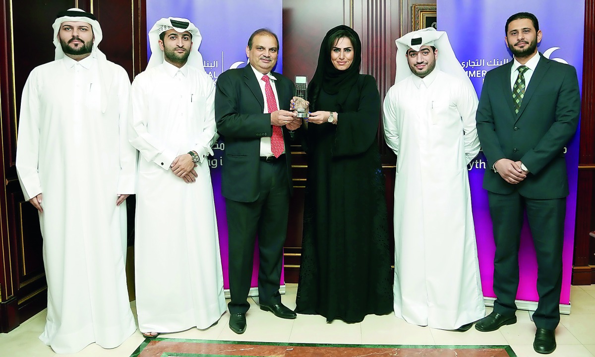 Roya Khajeh, Commercial Bank AGM, Head of Cards and Payments posing with the award with other officials.