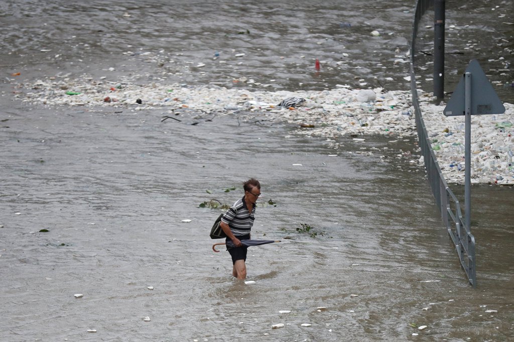 A man walks through a flooded street as Typhoon Hato hits Hong Kong, China August 23, 2017. REUTERS/Tyrone Siu
