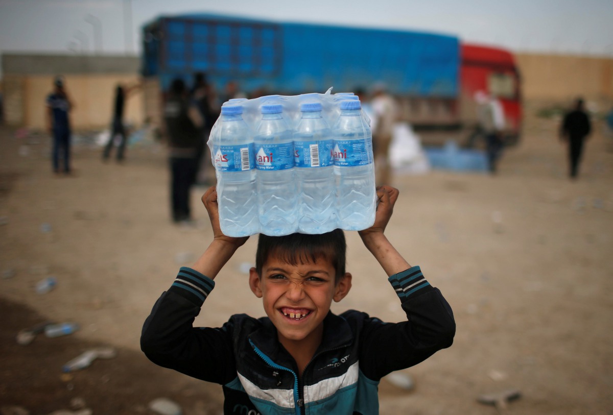 REPRESENTATIVE IMAGE: A displaced Iraqi boy smiles after receiving water in western Mosul, March 28, 2017 (Reuters/Suhaib Salem) 
