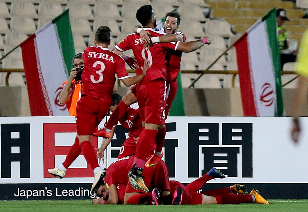 Syria's players celebrate after scoring a goal against Iran during the FIFA World Cup 2018 qualification football match between Iran and Syria at the Azadi Stadium in Tehran on September 5, 2017. / AFP / ATTA KENARE
