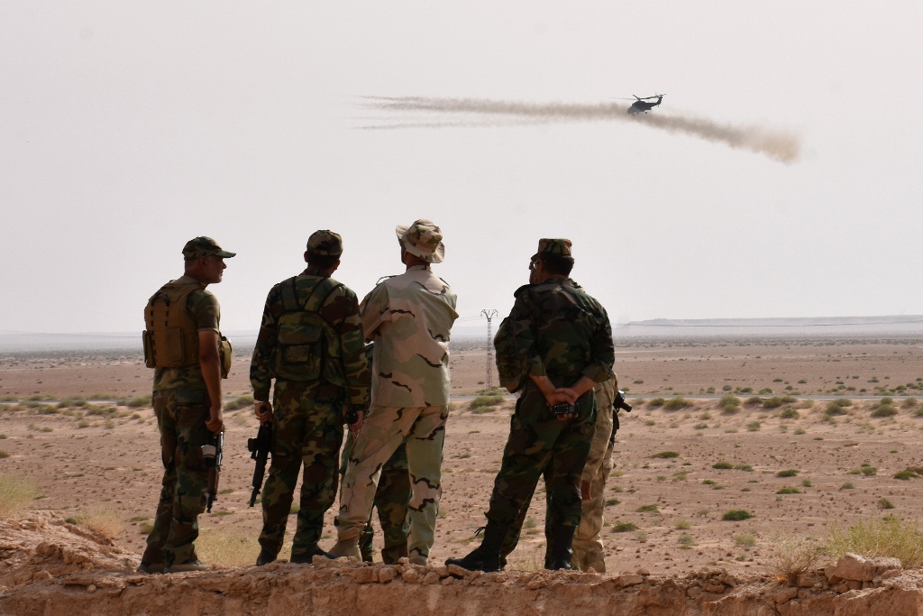 A helicopter fires rockets as Syrian government forces hold a position in Kobajjep area, on the southwestern outskirts of Deir Ezzor, on September 5, 2017, during the ongoing battle against Islamic State (IS) group.   AFP / George OURFALIAN
