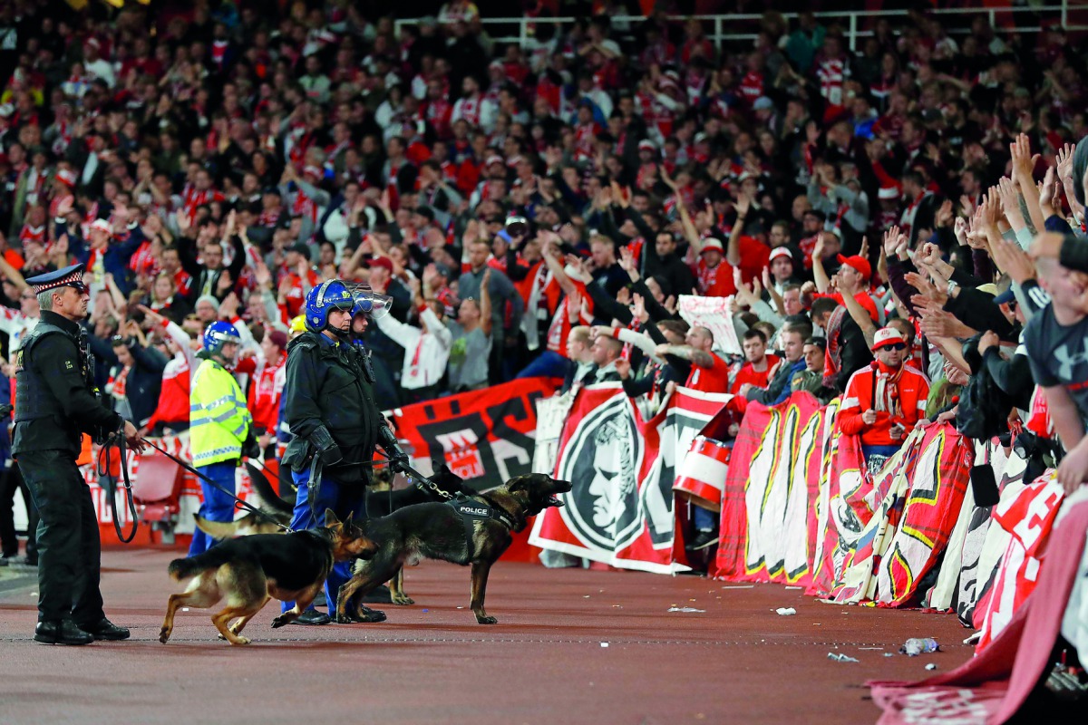 Police inside the stadium keep an eye on Cologne supporters in the stands as the kick off was delayed due to crowd safety issues ahead of the UEFA Europa League Group H football match between Arsenal and FC Cologne at the Emirates Stadium in London on Thu