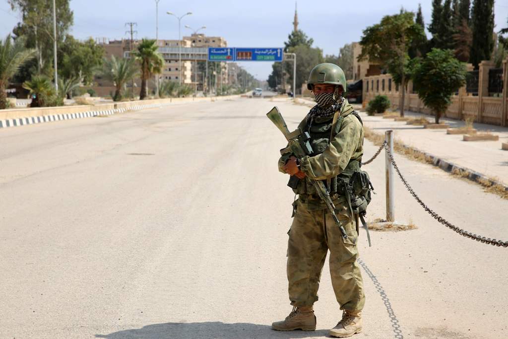 A picture taken during a press tour provided by the Russian Armed Forces on September 15, 2017 shows a Russian soldier standing guard in a central street in Syria's eastern city of Deir Ezzor. / AFP / Dominique DERDA