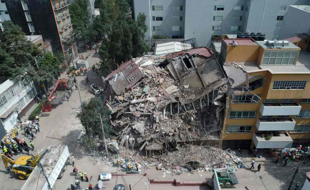 Aerial view of a flattened building in Mexico City taken on September 20, 2017 as the search for survivors continues a day after a strong quake hit central Mexico.  AFP / Mario VAZQUEZ
