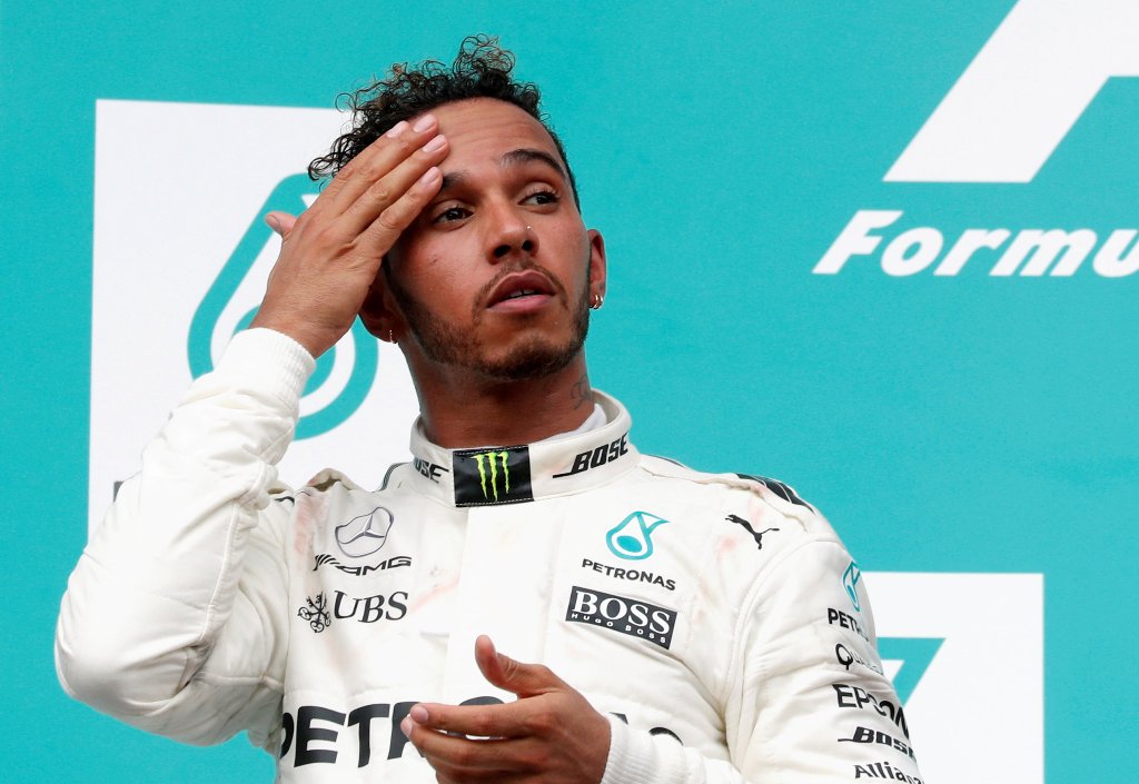 Mercedes' Lewis Hamilton wipes his forehead on the podium. REUTERS/Edgar Su
