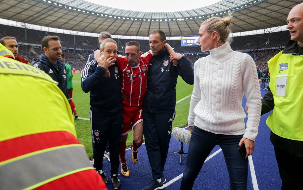 Bayern Munich's French midfielder Franck Ribery (C) is helped off the pitch by medical staff after injuring his knee during the German first division Bundesliga football match between Hertha Berlin and FC Bayern Munich in Berlin, on October 1, 2017.  AFP 