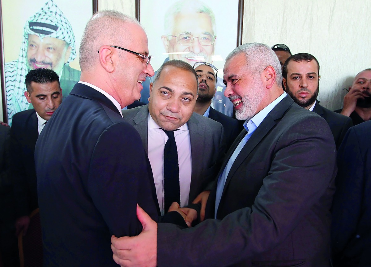 Hamas’ overall leader Ismail Haniyah (right) shakes hands with Palestinian Prime Minister Rami Hamdallah in Gaza City yesterday.