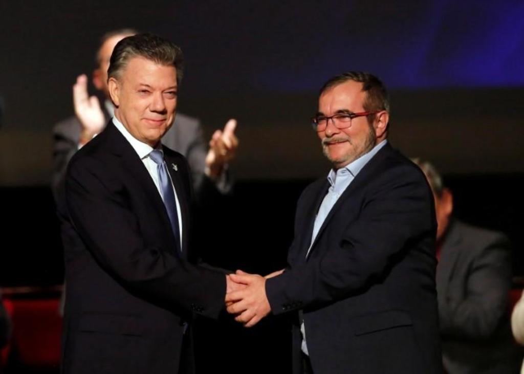 Colombia's President Juan Manuel Santos and Marxist FARC rebel leader Rodrigo Londono, known as Timochenko, shake hands after signing a peace accord in Bogota, Colombia November 24, 2016. REUTERS/Jaime Saldarriaga.