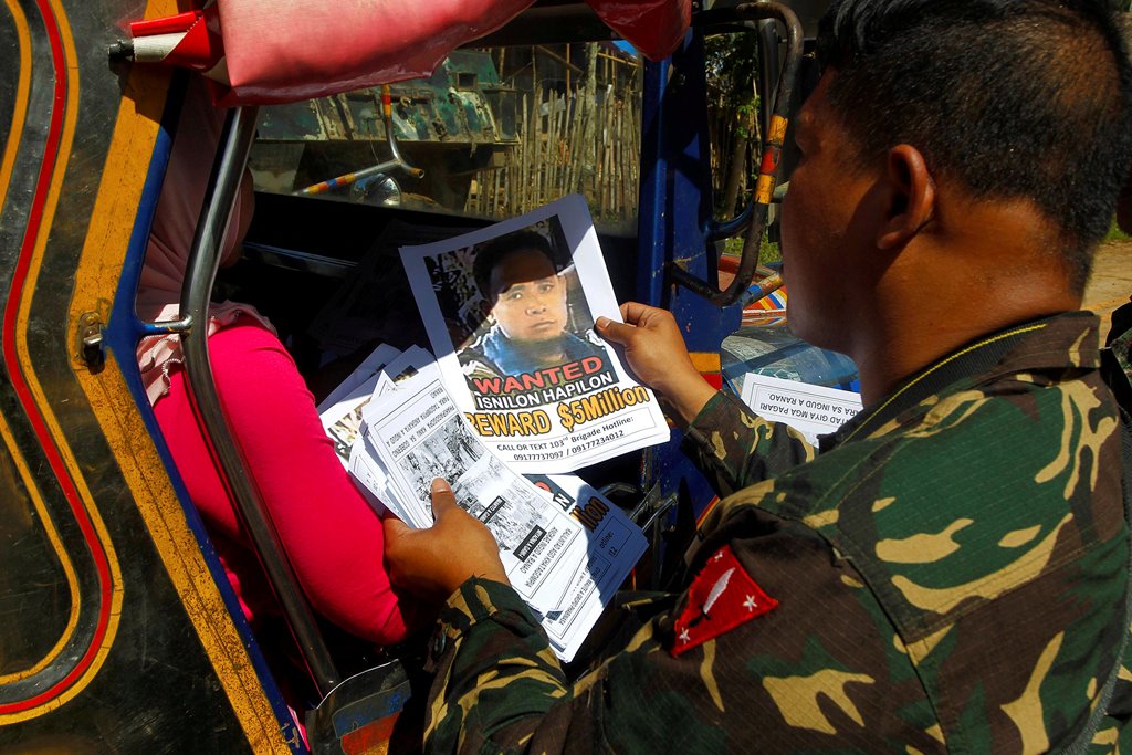 FILE PHOTO: Soldiers distribute pictures of a member of extremist group Abu Sayyaf Isnilon Hapilon, who has a U.S. government bounty of $5 million for his capture, in Butig, Lanao del Sur in southern Philippines February 1, 2017. REUTERS/Marconi B. Navale