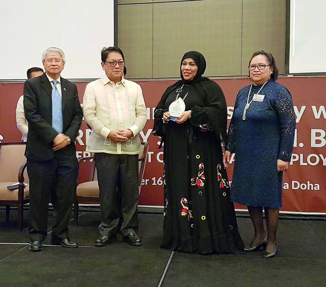 Philippine Labour and Employment Secretary Silvestre H Bello III (second left) with Qatari physician Dr Hanadi Al Hamad (second right)  after presenting a special award as Ambassador Alan L Timbayan (left) looks on.