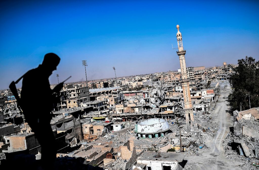 A member of the Syrian Democratic Forces (SDF), backed by US special forces, talks on the radio near Raqa's stadium as they clear the last positions on the frontline on October 16, 2017 in the Islamic State (IS) group jihadists crumbling stronghold.  AFP 