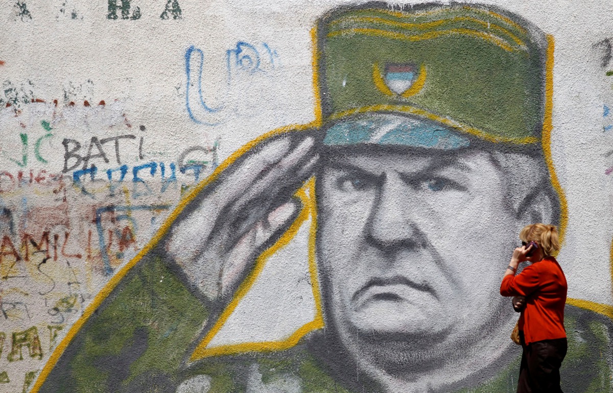 A woman walks past graffiti of Bosnian Serb wartime general Ratko Mladic in a suburb of Belgrade, Serbia, May 27, 2011 (Reuters / Stoyan Nenov) 