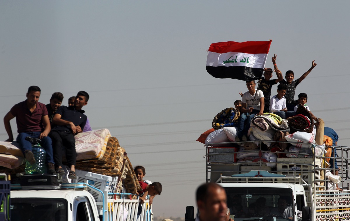A picture taken on October 18, 2017 shows displaced Iraqis, who fled from Hawija in 2014 to Kirkuk, riding in vehicles as they return to Hawija, after the town was retaken by Iraqi forces. AFP / Ahmad Al-Rubaye