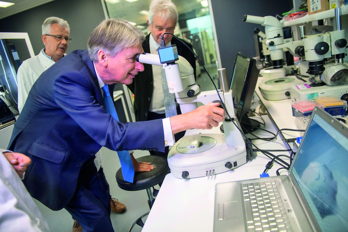 Britain's Finance Secretary Philip Hammond uses a microscope to examine protein crystals during his visit to The Francis Crick Institute in London, Britain October 25, 2017. Reuters/Chris J Ratcliffe