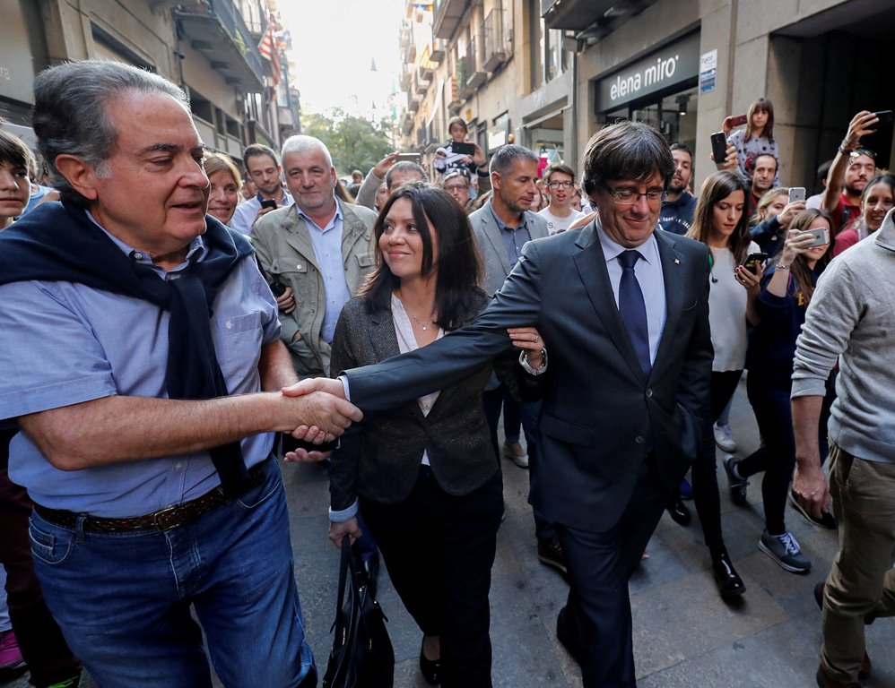 Sacked Catalan President Carles Puigdemont (R) walks with his wife Marcela Topor as he greets a supporter after leaving a restaurant the day after the Catalan regional parliament declared independence from Spain in Girona, Spain, October 28, 2017. Reuters