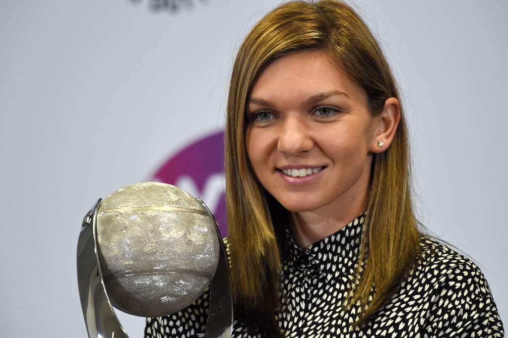 Simona Halep of Romania poses with her WTA year-end world number one trophy during the WTA Finals tennis tournament in Singapore on October 29, 2017. / AFP / ROSLAN RAHMAN
