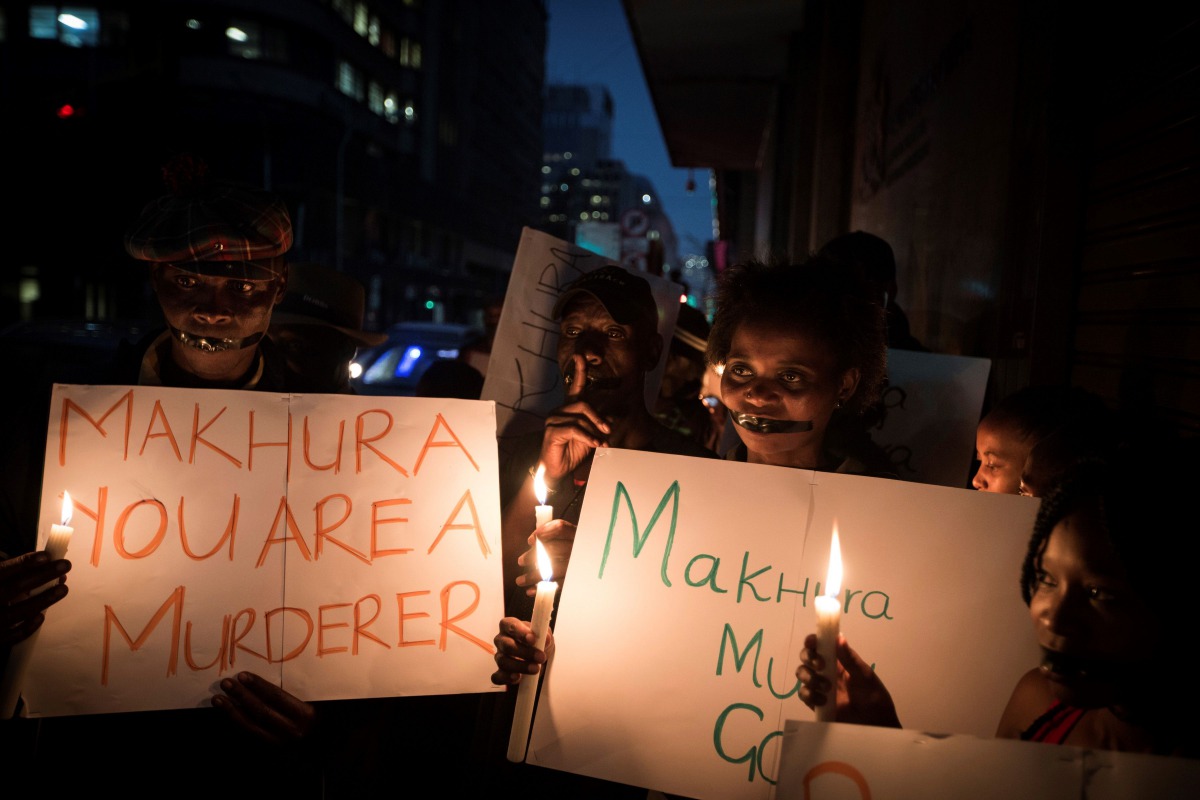 This file photo taken on February 2, 2017 shows relatives and family members of some of the 94 mentally ill patients who died last year, holding a candle light vigil organized by South African main opposition party Democratica Alliance (DA) outside the Ga