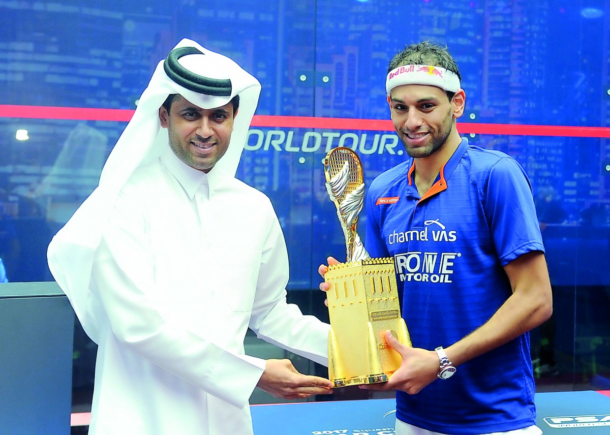 Nasser Ghanem Al Khelaifi, President of Qatar Tennis, Squash and Badminton Federation (QTSBF), hands Qatar Classic trophy to Mohamed El Shorbagy after he defeated Tarek Momen in the all–Egyptian final at Khalifa International Tennis and Squash Complex yes