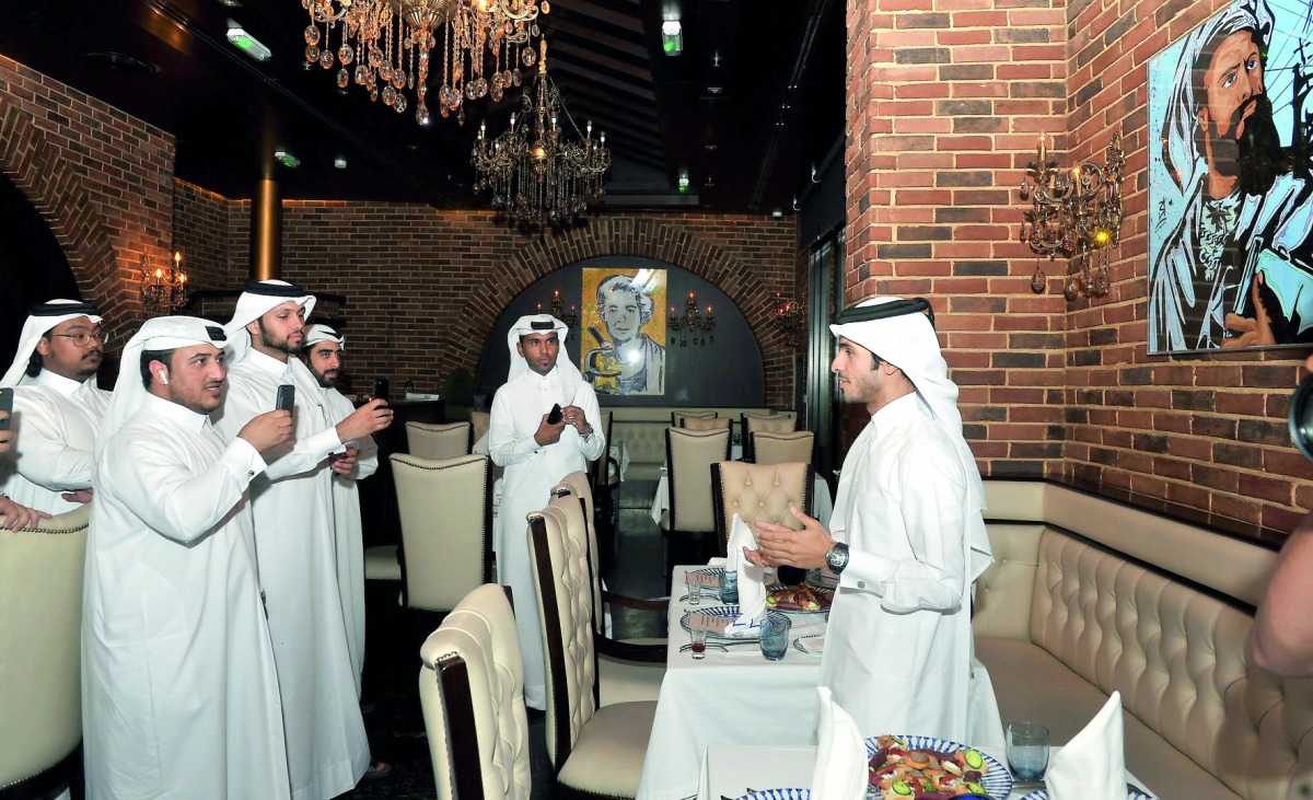 Ahmed Al Madheed (right) speaking at the unveiling of his latest paintings at Sasso Restaurant in Al Hazm Mall yesterday. Pic: Kammutty VP / The Peninsula