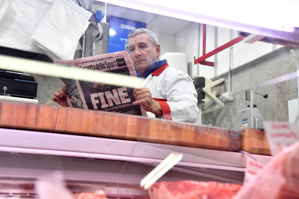 A butcher reads Italian sport newspaper 