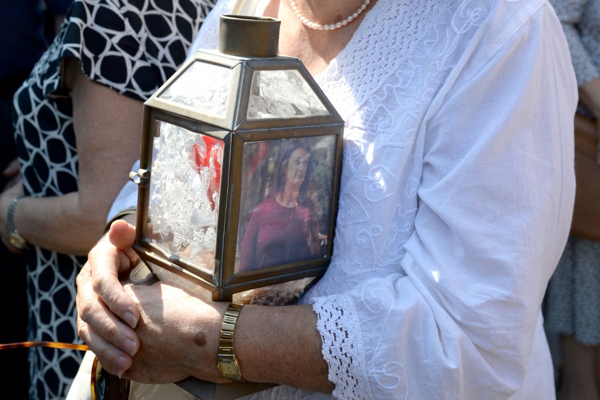 A woman holds a lantern with a picture of murdered journalist Daphne Caruana Galizia outside the law court in Valletta, Malta, on October 17, 2017 (AFP / Matthew Mirabelli) 