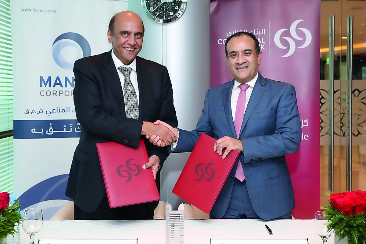 Alekh Grewal (left), Director & Group CEO of Mannai Corporation shakes hands with Joseph Abraham, Group CEO of Commercial Bank after signing partnership deal, yesterday. 