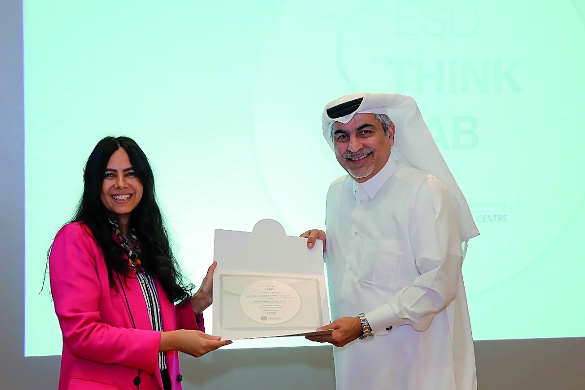 A QFC official receives the certificate from ILO represenatative.
