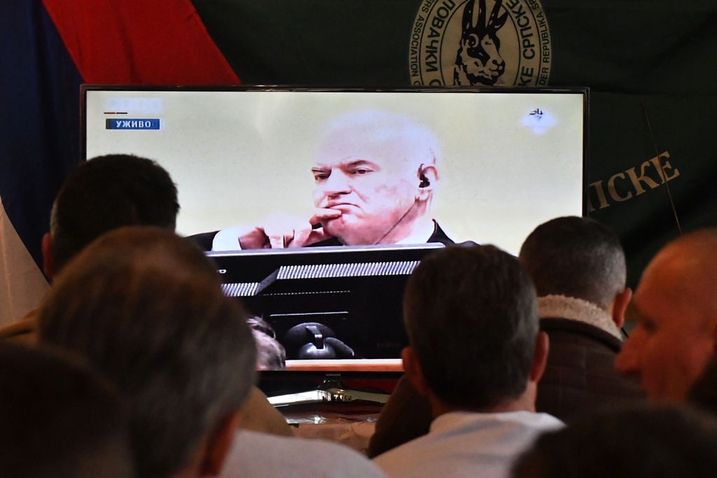 Former Bosnian Serbian commander Ratko Mladic appears on a TV screen wher people gather to watch a live broadcast from the International Criminal Tribunal for the former Yugoslavia (ICTY) on November 22, 2017 in Sokolac. AFP / Elvis Barukcic