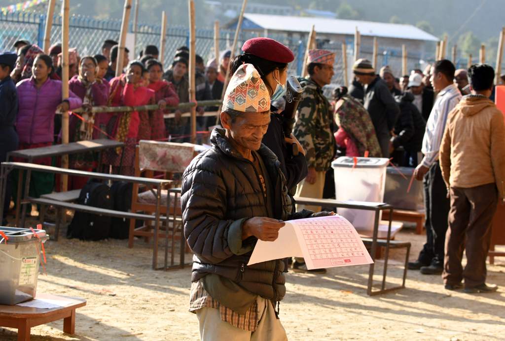 A Nepali voter examines a ballot papers before casting his vote at a polling station during the general election at Chautara, Sindhupalchowk district some of 100 kilometers east of Kathamndu on November 26, 2017./ AFP.