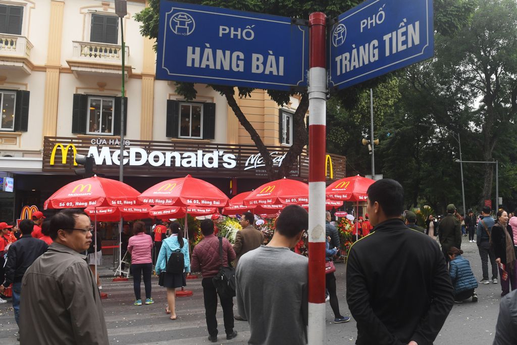 People stand around looking at the first McDonald's fast food chain restaurant in the capital city, on its opening day in Hanoi on December 2, 2017. / AFP / HOANG DINH NAM