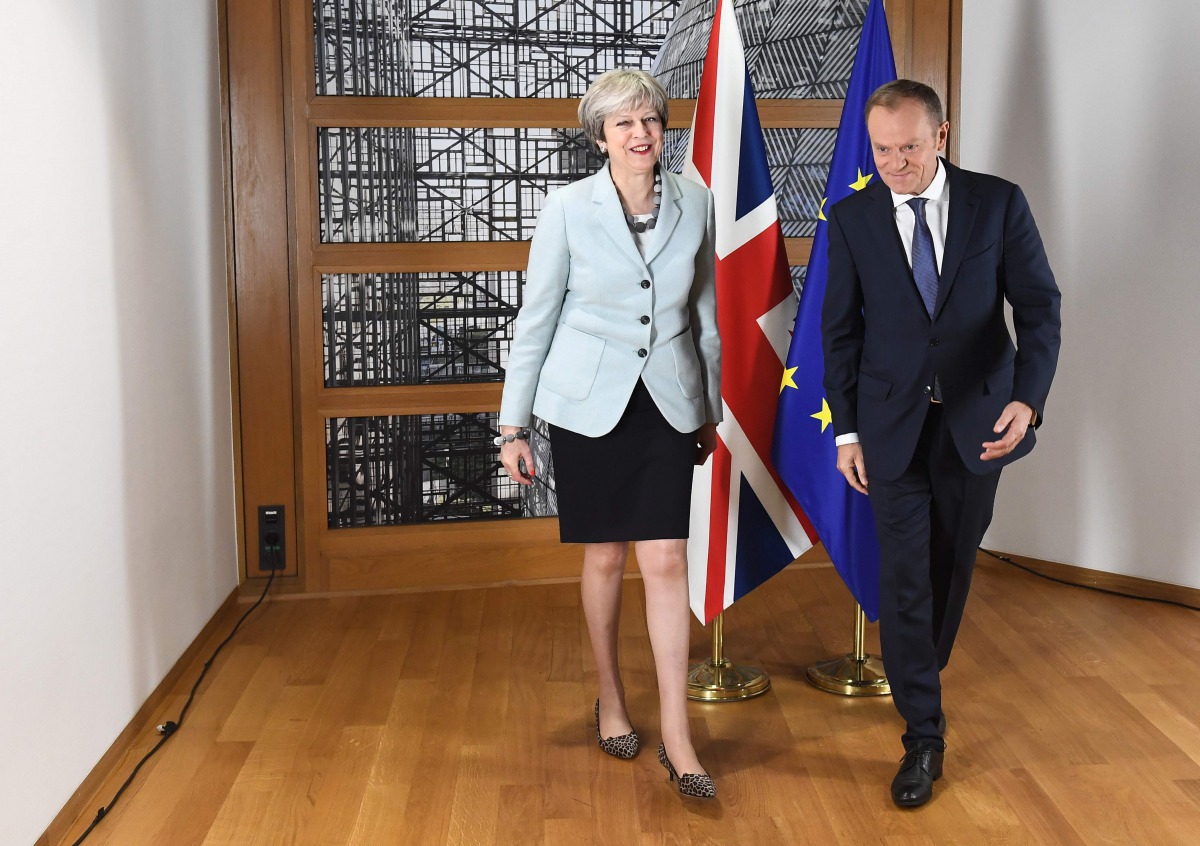 British Prime Minister Theresa May (L) and European Council President Donald Tusk leave after posing for photographers at the European Council in Brussels on December 8, 2017. ()AFP / EMMANUEL DUNAND)