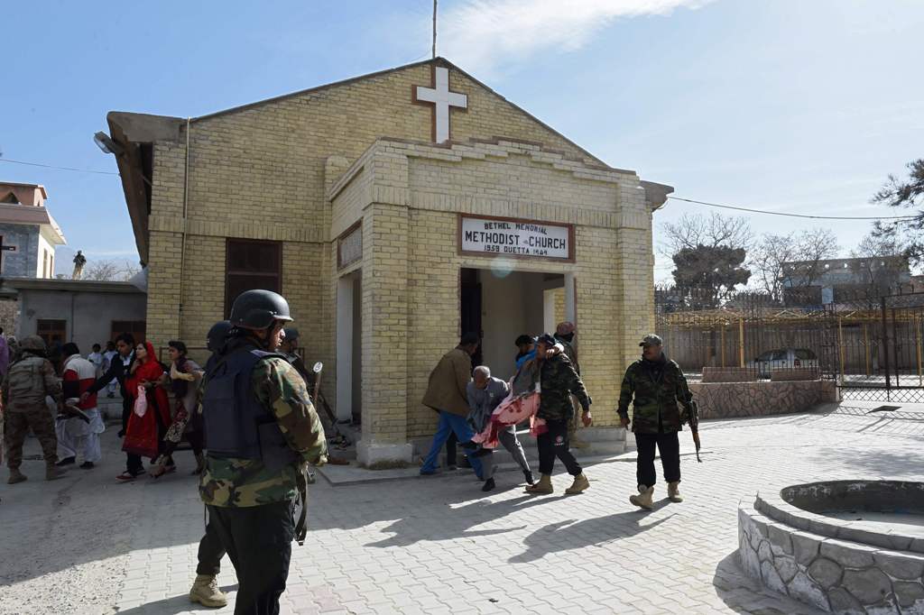 Pakistani security personnel rescue an injured woman after suicide bombers attacked a Methodist Church during a Sunday service in Quetta on December 17 2017.  AFP / BANARAS KHAN
