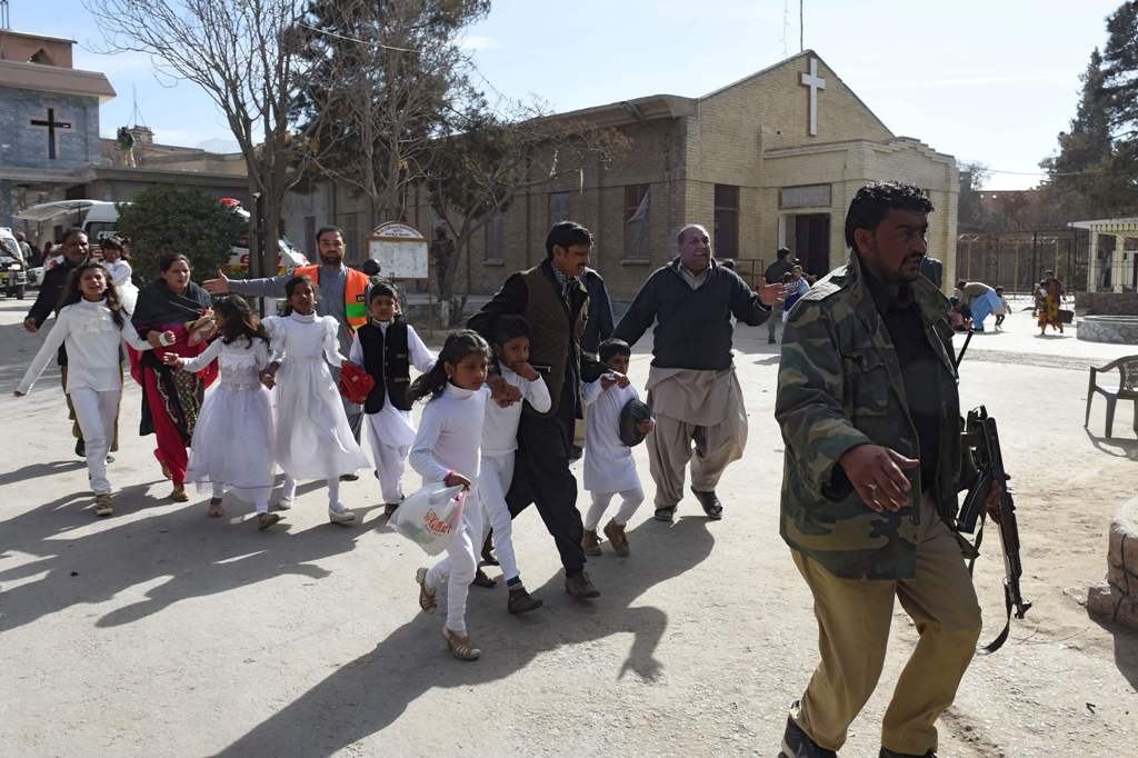 Pakistani Christian children are evacuated by security personnel from a Methodist church after a suicide bomber attack during a Sunday service in Quetta on December 17, 2017.  AFP / BANARAS KHAN
