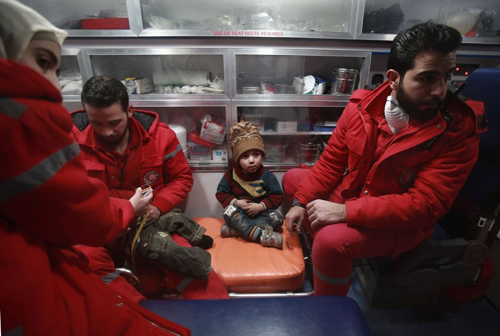 Syrian staff from the International Committee of the Red Cross take part in an evacuation operation in Douma in the eastern Ghouta region on the outskirts of the capital Damascus on December 26, 2017.  AFP / ABDULMONAM EASSA