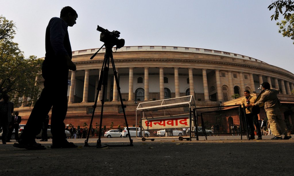 Television journalists report from the premises of India's Parliament in New Delhi, India, February 13, 2014. REUTERS/Adnan Abidi/File Photo
