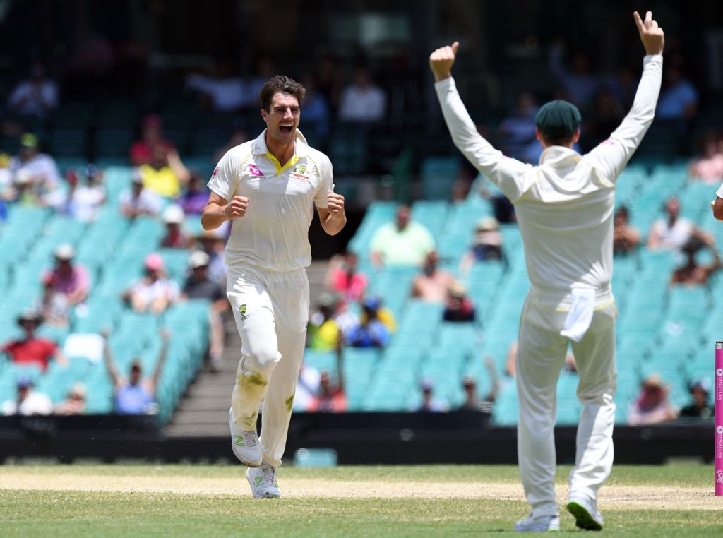 Australia's Pat Cummins (L) celebrates with captain Steve Smith (R) after dismissing England batsman Stuart Broad on the final day of the fifth Ashes cricket Test match at the SCG in Sydney on January 8, 2018. / AFP.