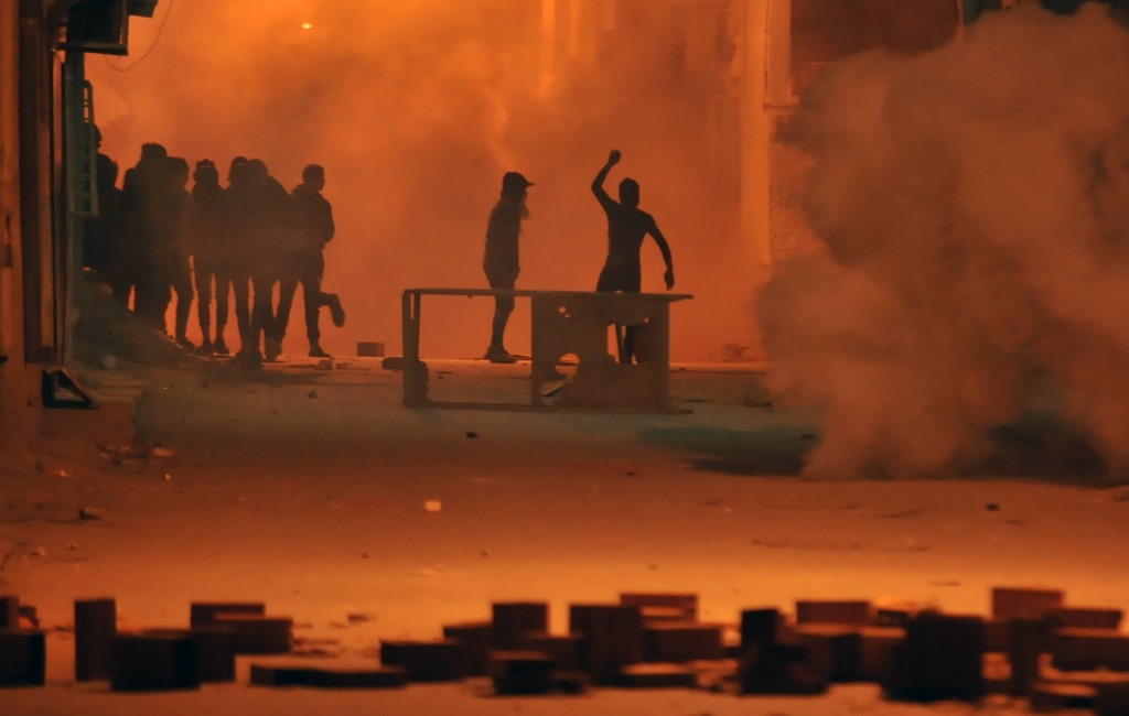 Tunisian protestors throw stones towards security forces in Tunis' Djebel Lahmer district early on January 10, 2018 after price hikes ignited protests in the North African country. AFP / Sofiene HAMDAOUI