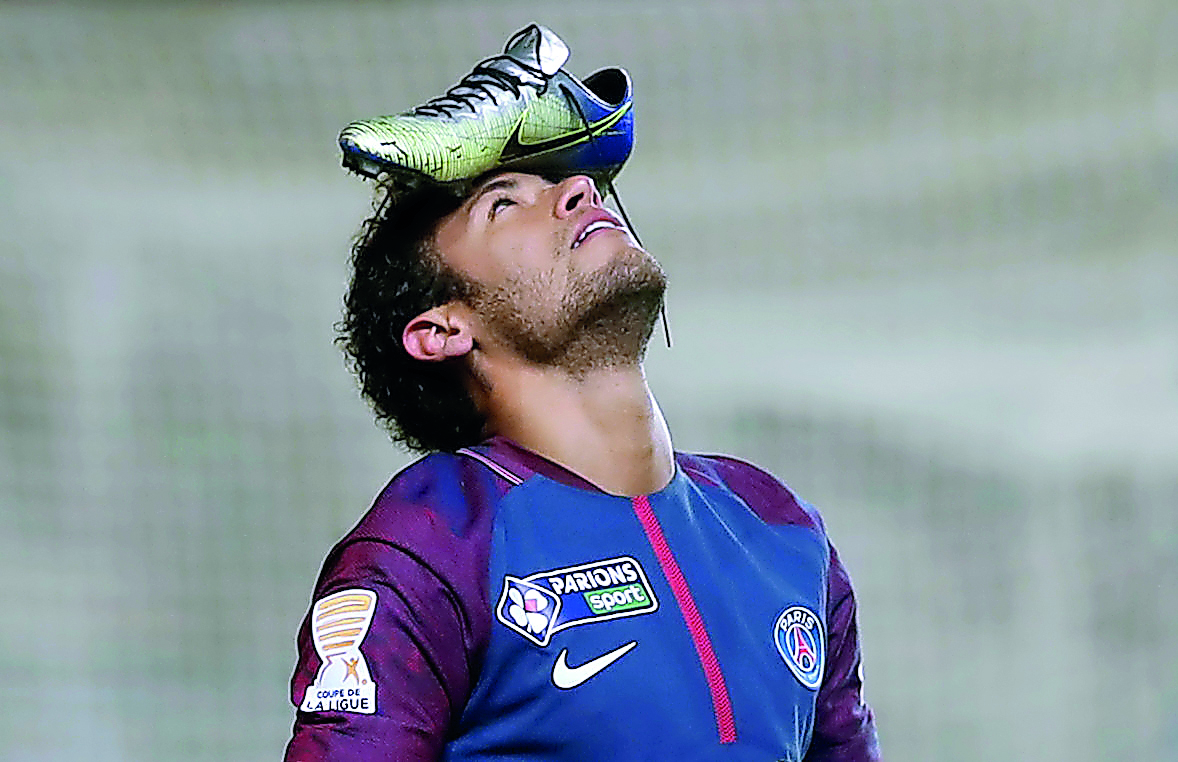 Paris Saint-Germain’s Neymar celebrates scoring their first goal from the penalty spot with his football boot on his head. Reuters/Benoit Tessier  