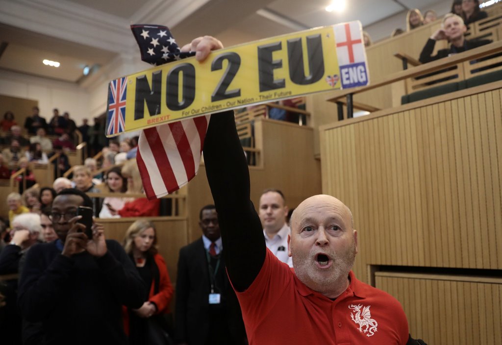 A demonstrator holds a pro-Brexit sign and a US flag, as the speech by the Mayor of London, Sadiq Khan, is interrupted in central London, Britain January 13, 2018. REUTERS/Simon Dawson