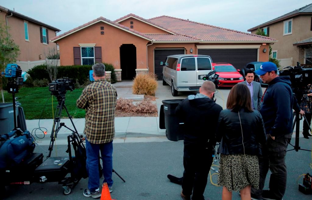 Media gather in front of 160 Muir Woods Road in Perris, California, from where authorities rescued 13 malnourished children held captive by their parents, on January 15, 2018. / AFP / Bill Wechter