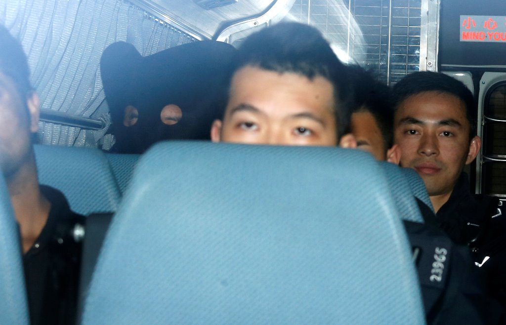 A South Korean man, covered with a mask, on suspicion of murdering his wife and seven-year-old son at a Ritz-Carlton hotel, sits inside a police wan as he is taken to a court in Hong Kong January 16, 2018. REUTERS/Bobby Yip