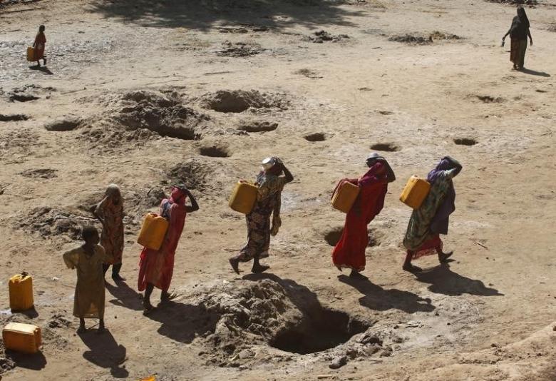 Women carry jerry cans of water from shallow wells dug from the sand along the Shabelle River bed which is dry due to drought in Somalian Shabelle region, March 19, 2016. Reuters / Feisal Omar